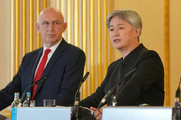 Britain's Defense Secretary John Healey listens to Australia's Foreign Affairs Minister Penny Wong